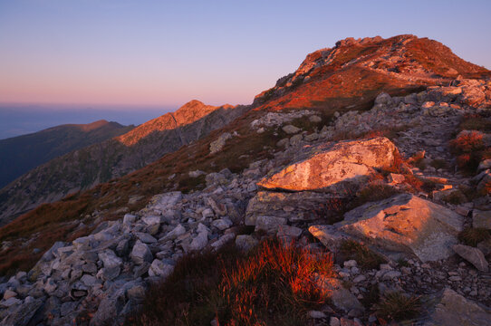 Aerial view of the rugged peak ablaze with the warm glow of sunrise, its rocky crags casting long shadows, Tri Kopy, Zilina Region, Slovakia.