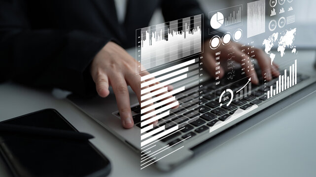A professional office setting featuring a person typing on a laptop while interactive financial graphs and data visualizations hover above, illustrating modern analysis methods. Impute