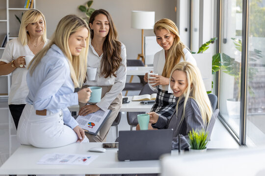 Group of diverse women collaborating and discussing ideas in a modern office space while enjoying coffee - Powered by Adobe