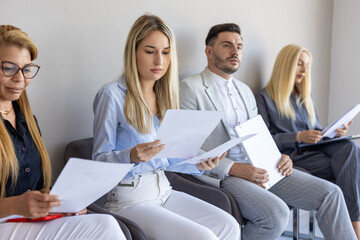 Fototapeta premium Candidates prepare for job interviews in a modern waiting area during a sunny morning