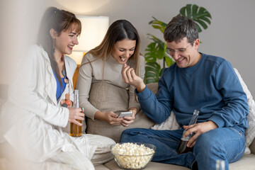 Friends enjoy movie night with popcorn and drinks in cozy living room setting with plants