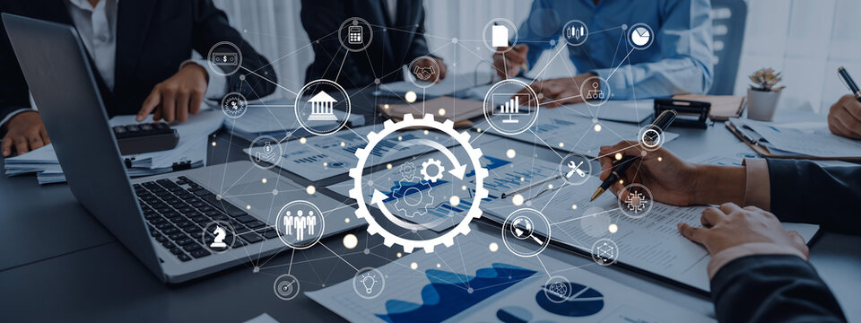 A modern business team collaborates in an office setting, utilizing technology and data analysis to drive strategy and innovation during a meeting. Trope