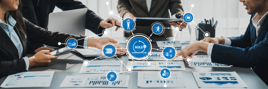 A dynamic business meeting featuring a diverse team collaborating over data visualizations and strategic planning in a modern office environment, promoting teamwork and innovation. Amity