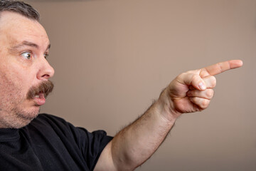 A man with a mustache pointing to something
