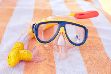 Colorful snorkeling gear with mask and snorkel resting on a striped towel for summer adventures