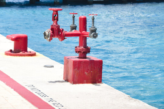 Red fire pump connection on a harbor pier