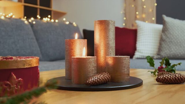 Christmas Home Decorations &ndash; Modern Advent Arrangement With Two Lit Golden Candles on a Wooden Coffee Table