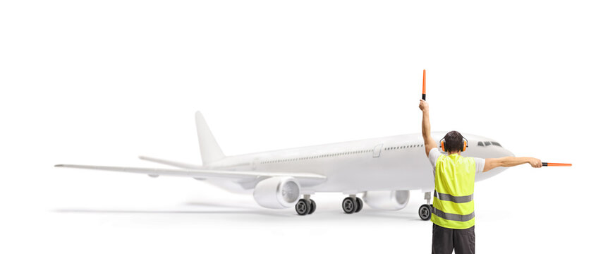 Aircraft marshaller signalling with wands in front of a plane