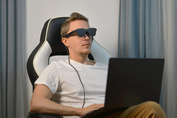 Man Using Wearable AR XR Smart Glasses While Using Laptop