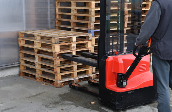 Warehouse worker operating electric pallet stacker