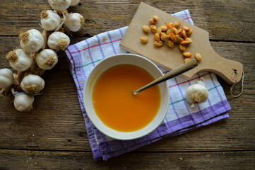 Healthy Vegan Pumpkin Soup. Top view. Wooden background with garlic and pumpkin seeds. 