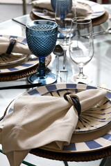 Close-up of sophisticated table settings with plates, cutlery, bowls, and glasses for beautiful events and dinners.