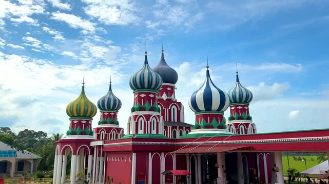 Besut, Terengganu, Malaysia - &lrm;November 27, 2025 - A vibrant Russian-style mosque with eight colorful onion domes under a bright blue sky in Besut, Terengganu.