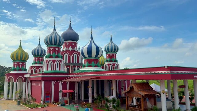 Besut, Terengganu, Malaysia - &lrm;November 27, 2025 - A vibrant Russian-style mosque with eight colorful onion domes under a bright blue sky in Besut, Terengganu.