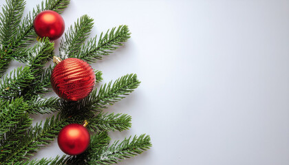 Festive evergreen branch with red bauble ornaments, snow dusting, holiday decoration and cozy seasonal atmosphere evoking celebration and warmth