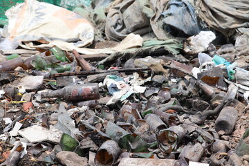 Weak dog resting on garbage heap within unhealthy contaminated area filled with plastics