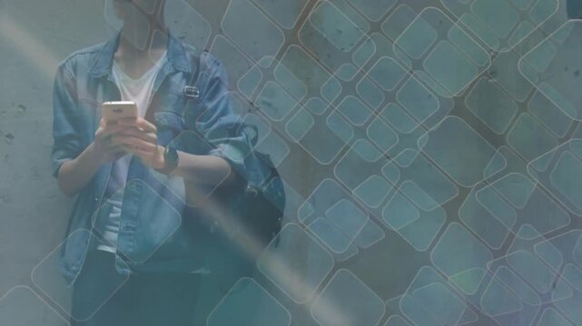 Tech student leaning on wall, framing shifting revealing, scrolling phone checking texts under grid