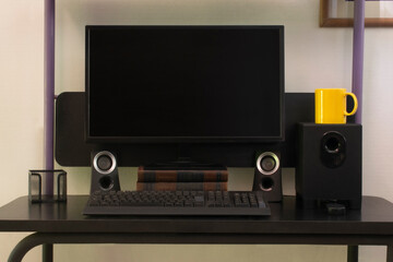 Black computer and yellow mug.
