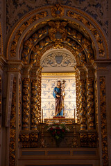 Statue of Saint Joseph with Jesus Christ in his lap prominently displayed on the altarof the Christian church of Saint Sebastian of Pedreira in Lisbon.