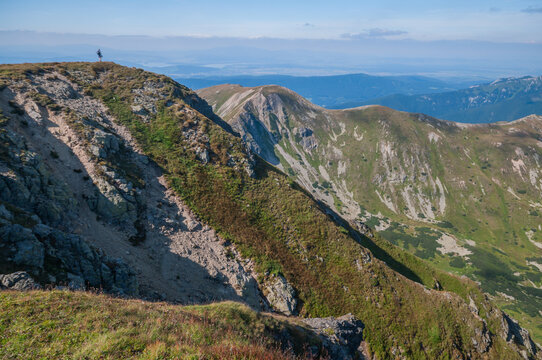 View of rugged mountain terrain under a clear sky, with patches of green vegetation clinging to the slopes, Bobrovec, Zilina Region, Slovakia.