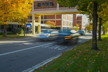 Vehicular traffic on busy city street, vehicles are blurred to emphasized motion. 