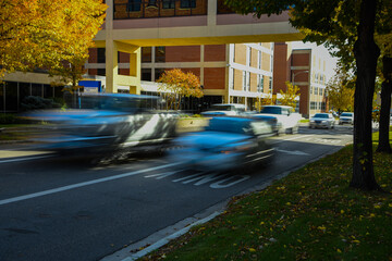 Vehicular traffic on busy city street, vehicles are blurred to emphasized motion. 