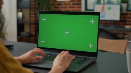 Woman typing on a laptop with a green screen for mockup and editing, ideal for advertising and educational content - Powered by Adobe