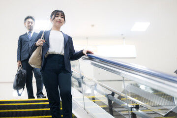 Business commuting scenes of career women in suits descending escalators at airports and stations