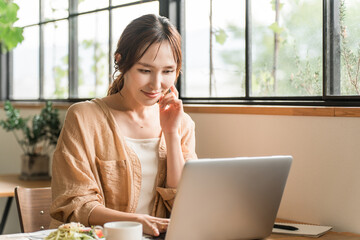 A woman working remotely while having lunch at a cafe
