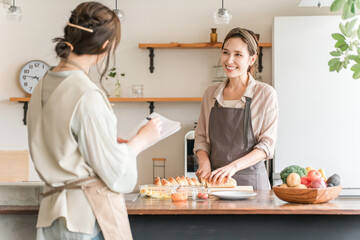 A female instructor and a female student teaching cooking at a cooking class/cooking school
