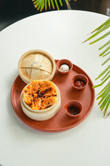 Dim Sum Platter with Chili and Soy Sauces on White Background
