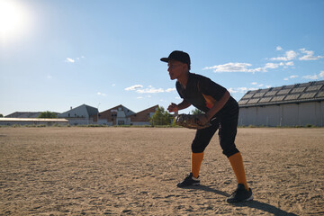 Young male baseball player preparing to catch during game practice outdoors