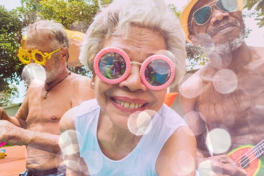 Closeup of diverse senior adults sitting by the pool enjoying summer together