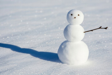 An adorable miniature three tiered snowman standing in a field of pristine white snow