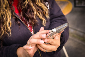 Woman using smartphone outdoors in casual jacket