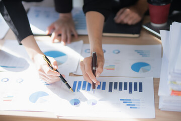 Smiling Asian businesswoman shaking hands with colleagues in office meeting, working together to...