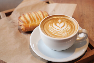Creamy coffee and pastry on a wooden table