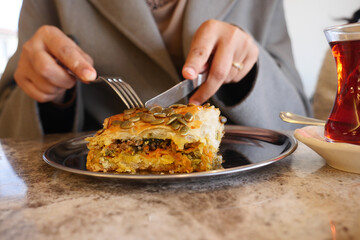Enjoying a delicious layered dish with tea