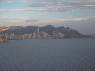 Fototapeta premium evening glow over urban shoreline, dusk casts amber light on metropolitan coastlines and peaks