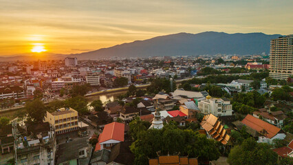 Obraz premium drone aerial sunset of Chiang Mai Thailand cityscape old town temples mountains and ping river, travel destination 