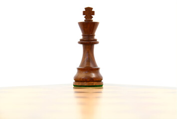 Wooden Chess King Piece Standing Alone on a Chessboard on White Background