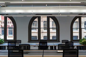 Modern open plan office arched windows empty desks natural light