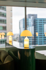 Warm modern table lamp glows contemporary office lounge city backdrop
