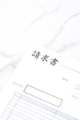 請求書 - 取引先へ宛てて請求書を準備する、ビジネスシーンのイメージ

