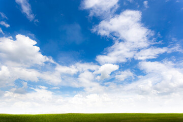 Stratocumulus clouds in the blue sky with a green filed for background
