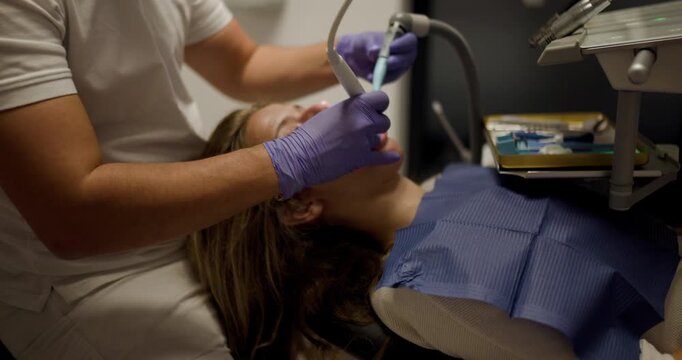 Dental appointment at a clinic with a patient receiving treatment from a dentist in a modern setting during late afternoon hours