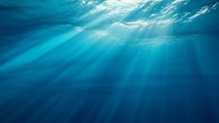 Sunlight beams dramatically pierce deep blue ocean water creating mesmerizing underwater light rays and peaceful serene atmosphere for exploration and calm