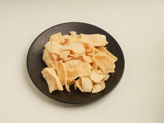 Crispy potato snacks piled on black plate