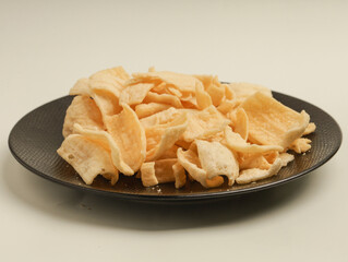 Crispy potato snacks piled on black plate