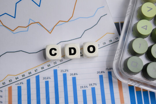 CDO stacked wooden cubes with financial graphs on the table.